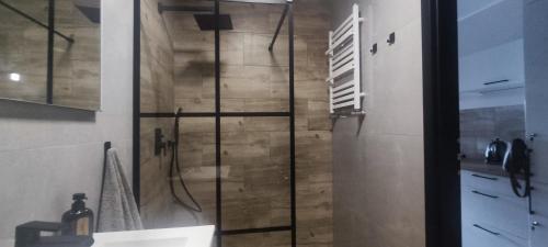 a shower with a glass door in a bathroom at Apartament Promenada Czaplinek in Czaplinek