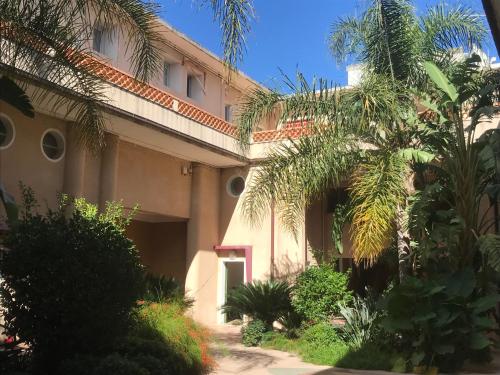 a building with palm trees in front of it at Blue Summer Vibes Appartment for 4P, AC, parking, beachfront, SPA access -5 in La Ciotat