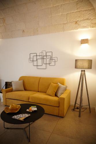 a living room with a yellow couch and a table at Casetta Zio Franco in Polignano a Mare