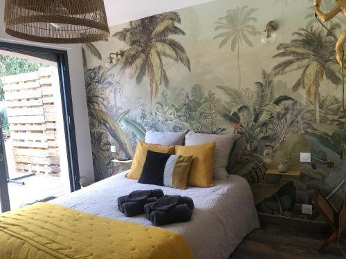 ein Schlafzimmer mit einem großen Bett und einer tropischen Tapete in der Unterkunft Le paradis des ouches in Aubigny