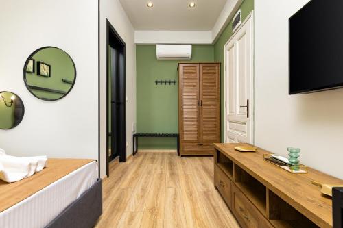 a bedroom with green walls and a bed and a mirror at Kapana Guest House on Central Pedestrian street with Parking included in Plovdiv