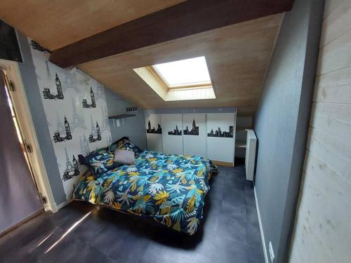 ein Schlafzimmer mit einem Bett und einem Dachfenster in der Unterkunft Le domaine lyonnais pour groupe in Violay