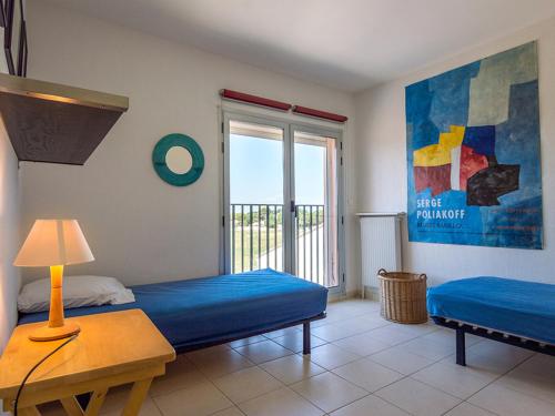 a room with two beds and a window with a balcony at Appartement Mèze, 4 pièces, 6 personnes - FR-1-604-5 in Mèze
