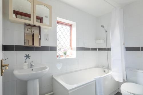 a white bathroom with a sink and a toilet at Foxdale's - 5 Bedroom House in Peterborough perfect for groups and families in Peterborough