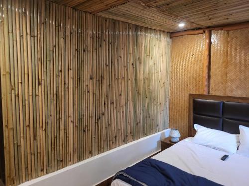 a bedroom with a bed and a wooden wall at Royal Tree Cafe And Resort in Dehradun