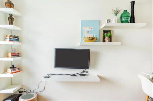 a white wall with a computer monitor on a desk at Staycation in Manila (2 min. walk to Robinson's) in Manila