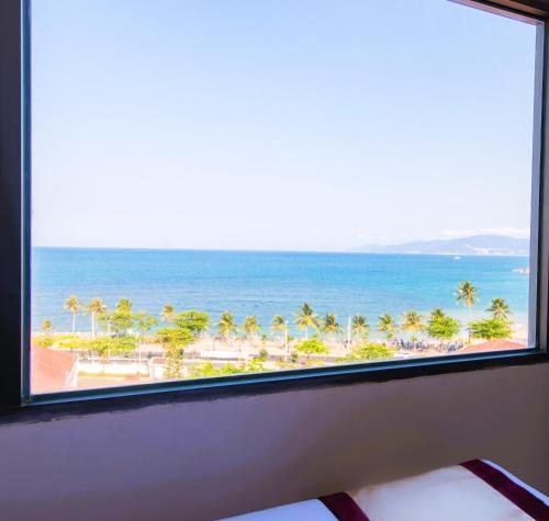 a view of the beach from a hotel room window at Arise Seaside Hotel in Nha Trang