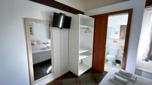 een badkamer met een spiegel en een toilet. bij Pousada Noantri in Búzios
