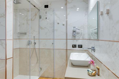 a bathroom with a sink and a shower at RoccaRegina Hotel in Sciacca