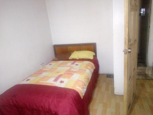 a small bedroom with a bed in a room at Escocie Quito Colonial in Quito