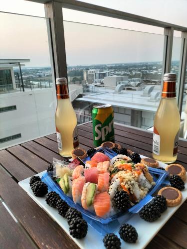 a plate of food and two bottles of beer at Darwin Harbour Suites in Darwin