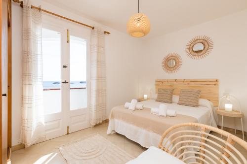 a bedroom with a bed and a view of the ocean at Binilaya in Sant Lluis