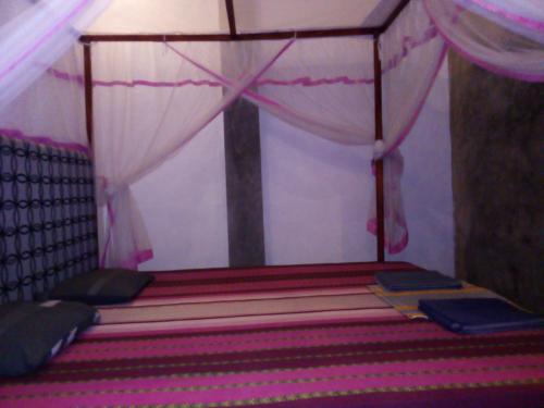 a room with a bed with a canopy and a cross at Villa Maleena in Hikkaduwa