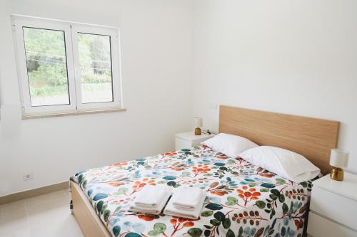ein Schlafzimmer mit einem Bett mit zwei Handtüchern darauf in der Unterkunft Casa Vilar in Ponte de Lima