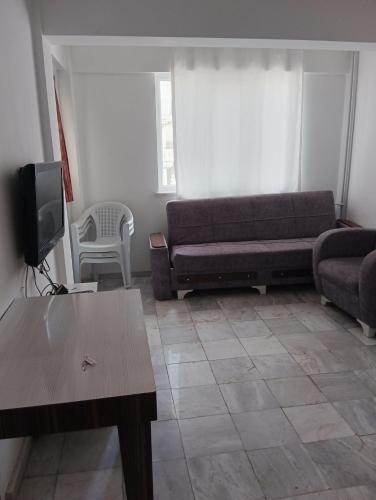 a living room with a couch and a tv at Rainford aprt in Denizli