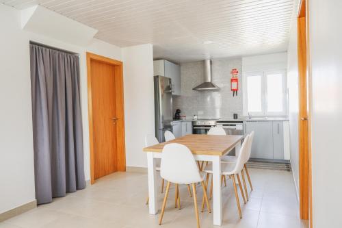 a kitchen and dining room with a wooden table and chairs at Casa Vilar in Ponte de Lima