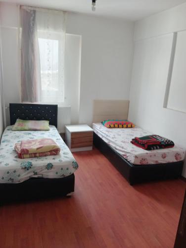 a bedroom with two beds and a wooden floor at Rainford aprt in Denizli