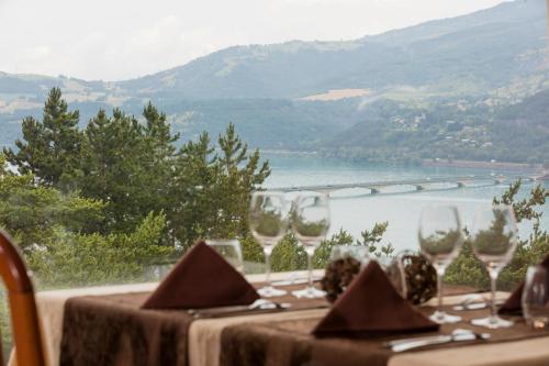 a table with wine glasses and a view of a river at Logis Hotel Eden Lac in Savines