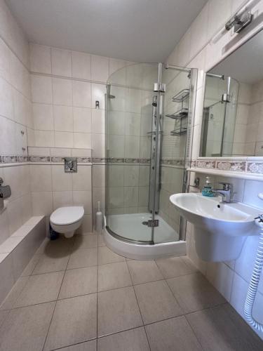 a bathroom with a shower and a toilet and a sink at Apartament Międzyzdroje z widokiem na morze in Międzyzdroje