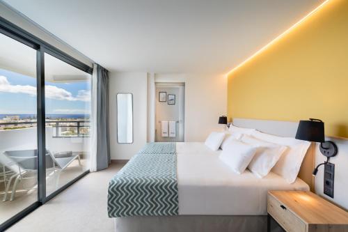Habitación de hotel con cama y balcón en Barceló Margaritas Royal Level Adults Only, en Playa del Inglés