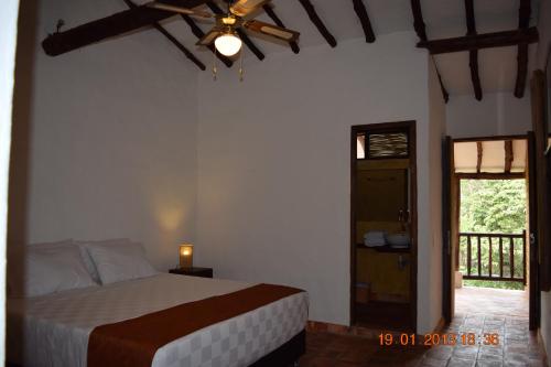 a bedroom with a bed and a ceiling fan at Casona CHARA in Barichara