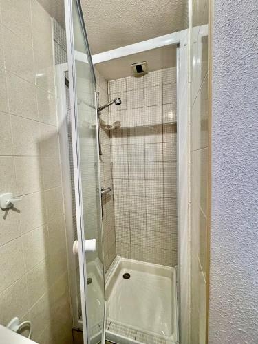 une douche avec une porte vitrée dans une salle de bain dans l'établissement Ô Cocon Montagnard, à Eaux-Bonnes