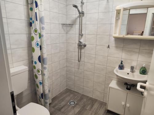 a bathroom with a shower and a toilet and a sink at Lucky Hostel in Luckenwalde