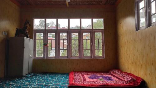 a room with a bed in front of a window at POP Nafia Homestay in Bhadarwāh