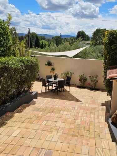 a patio with a table and chairs and a wall at B&B Finca la Yuca "Un paraíso en Ontinyent" in Ontinyent
