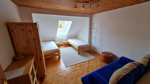 a living room with a blue couch and a window at Penzion PIANO in Liptovský Mikuláš