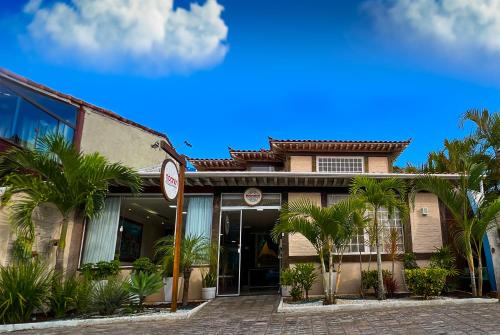 un edificio con palme di fronte di Pousada Noantri a Búzios