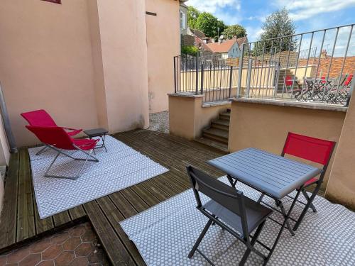 a patio with two chairs and a table on a balcony at Montbard appartements au centre historique chez Delphine et Guillaume in Montbard