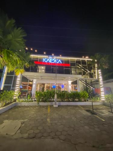 a building with a neon sign in front of it at Kaloka Airport Hotel in Labu Sumbawa