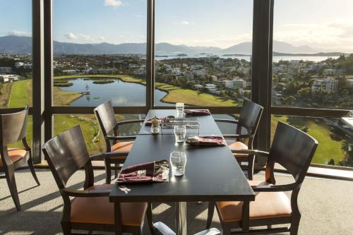 a dining room with a table and chairs and a view at Ramada Hotel & Suites by Wyndham Noumea in Noumea