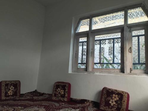 Habitación con 2 sillas y ventana en POP Masrat Homestay 
