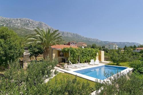 a villa with a swimming pool in a garden at Eden Holiday House with private Pool and Vineyard in Kaštela