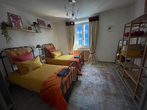 een slaapkamer met 2 bedden en een raam bij la maison des chapeliers in Carcassonne