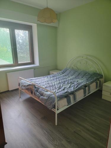 a bedroom with a bed in a room with two windows at Sunny apartment next to a beautiful lake in the forest in Imatra