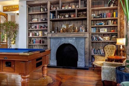 a living room with a fireplace and a table at The Shakespeare Hotel in Auckland
