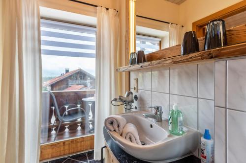 La salle de bains est pourvue d'un lavabo et d'une fenêtre. dans l'établissement Ferienwohnung Geierstein, à Wackersberg