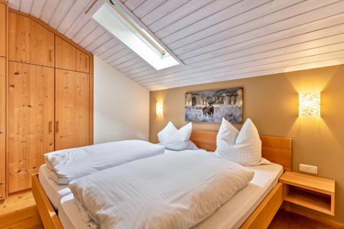 a bedroom with a large white bed with a skylight at Ferienwohnung Geierstein in Wackersberg