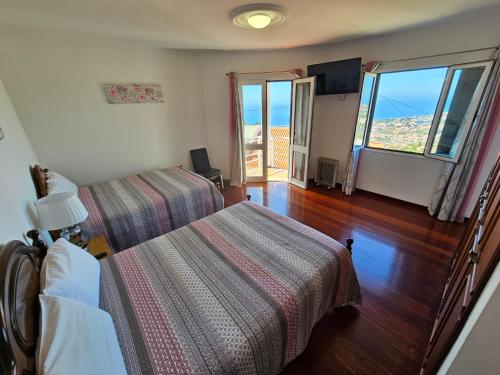 a bedroom with two beds and a view of the ocean at Casa de Feria do Livramento in Funchal