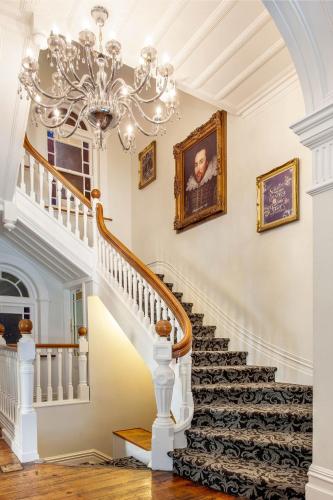 a staircase with a chandelier in a house at The Shakespeare Hotel in Auckland