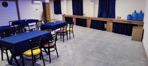 a room with tables and chairs with blue tables and yellow seats at OYO Sailors Galley in Gwalior