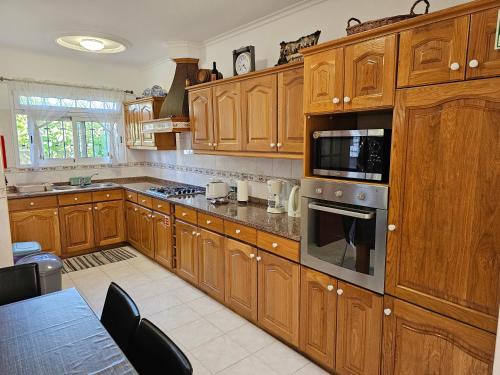a kitchen with wooden cabinets and a stove top oven at Casa de Feria do Livramento in Funchal