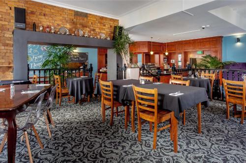 a restaurant with tables and chairs in a room at The Shakespeare Hotel in Auckland