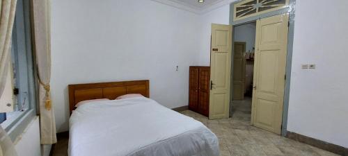 a small bedroom with a bed and a closet at Omah Tegal Panggung 44 in Sentool