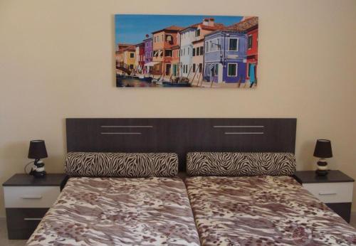 1 dormitorio con 1 cama y una pintura en la pared en Bellavista en Aigues