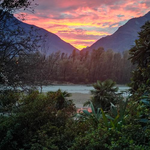 a sunset over a body of water with mountains at Il nido dei cigni in Vogogna