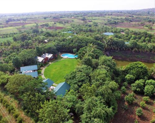 an aerial view of a house with a river and trees at Aranyagiri Countryside Resort, Near Pune in Pune